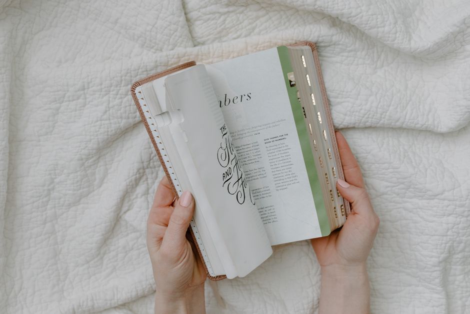 Bible open to Genesis chapter 39 for verse-by-verse commentary and study