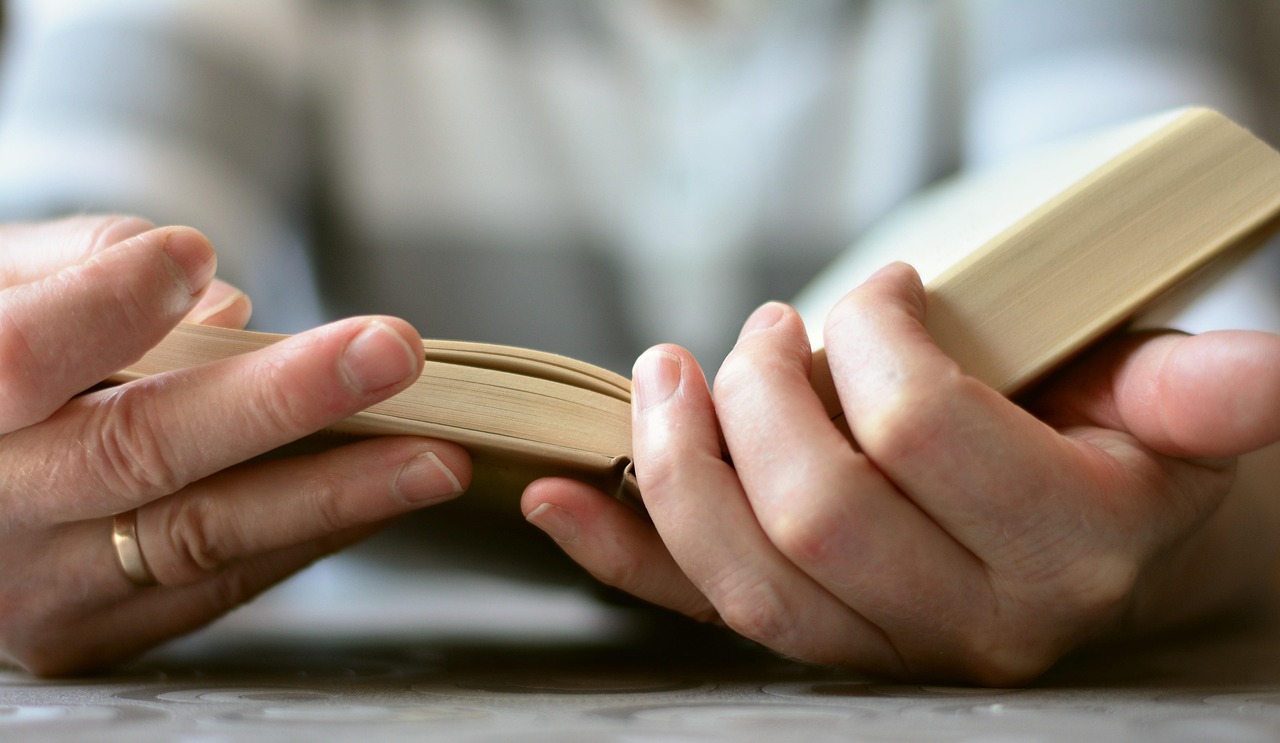 Bible open to Revelation chapter 20 for verse-by-verse commentary and study