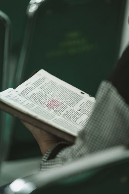 Bible open to Revelation chapter 1 for verse-by-verse commentary and study